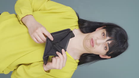 Vertikales-Video-Einer-Mittellosen-Frau,-Die-Auf-Ihre-Leere-Brieftasche-Schaut.